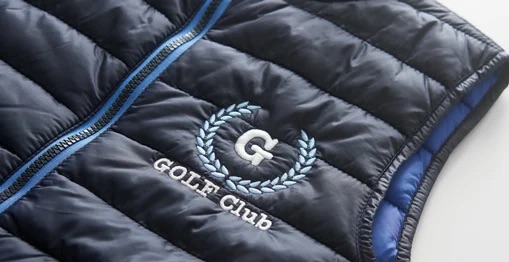 Iz&scaron;uvuma logotips uz stepētas tum&scaron;i zilas jakas &mdash; Golf Club emblema